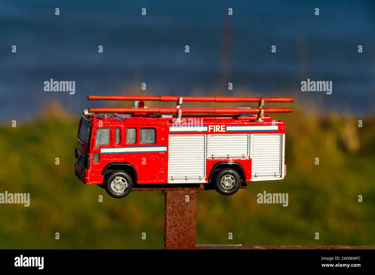 Modellino in scala pressofuso di camion dei pompieri montato sulla panchina del parco in memoria di papà e nonno, Blyth Northumberland Foto Stock