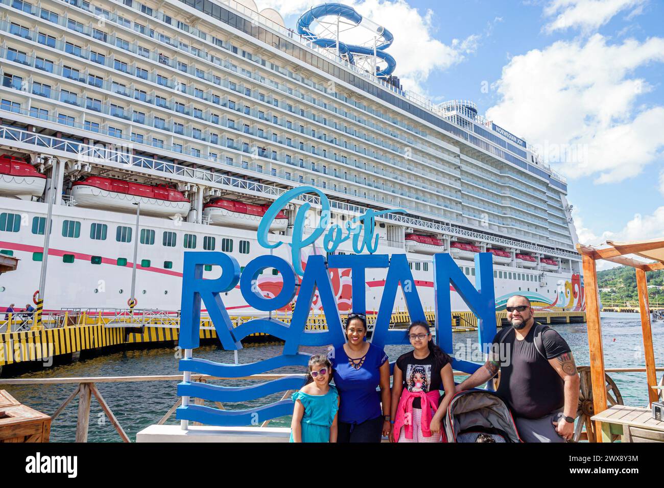 Port Roatan Honduras, isole della baia di Coxen Hole, nave da crociera Norwegian Joy Cruise Line, itinerario di 7 giorni del Mar dei Caraibi, opportunità di scattare foto con un cartello, posa asiatica Foto Stock