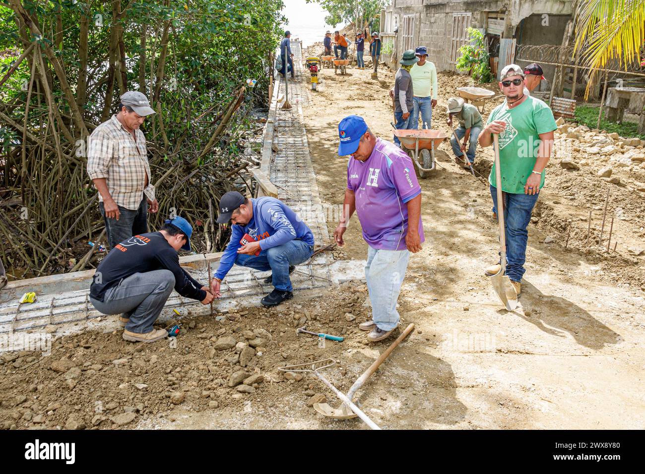 Port Roatan Honduras, Coxen Hole, Bay Islands, Main Street, lavori di riparazione di strade in corso di costruzione, uomini uomini, adulti, lavoratori Foto Stock