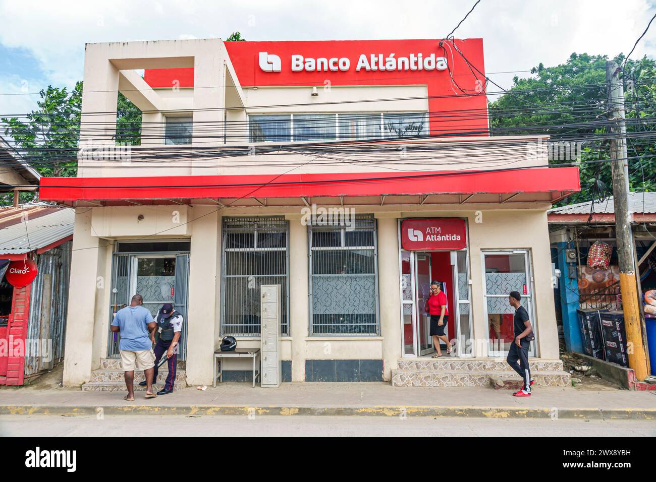 Port Roatan Honduras, Coxen Hole, Bay Islands, Main Street, Banco Atlantida Bank, ingresso esterno, guardia di sicurezza clienti che mi usa Foto Stock