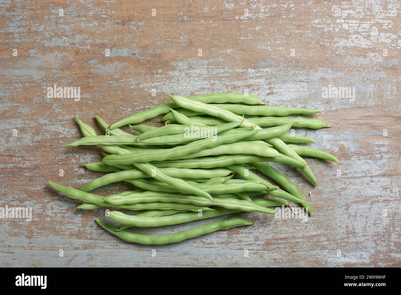 fagioli verdi su tavolo in legno, cordoncino, fagioli a pressione o bottoni, verdure per una consistenza croccante, sapore delicato e nutrizionale, vista dall'alto con spazio per copiare Foto Stock