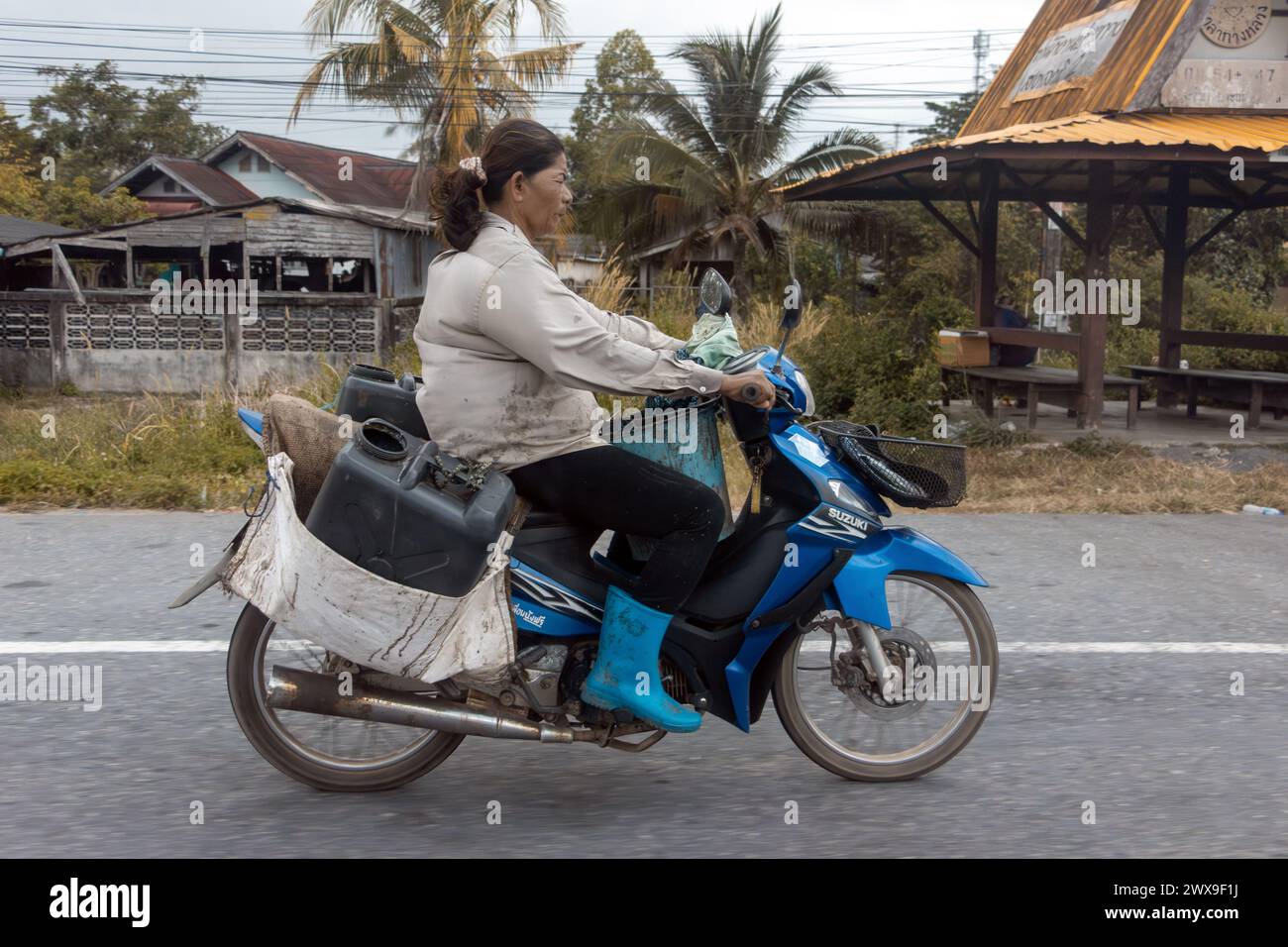 YALA, THAILANDIA, Mar 01 2024, Una donna guida una moto con un carico Foto Stock