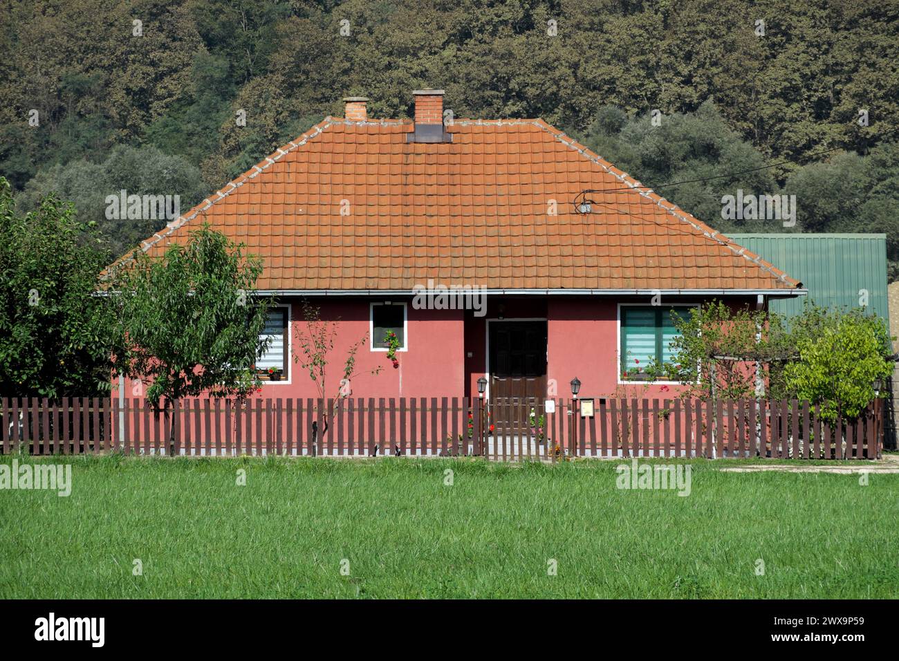 Casa piccola e semplice con recinzione in Serbia Foto Stock