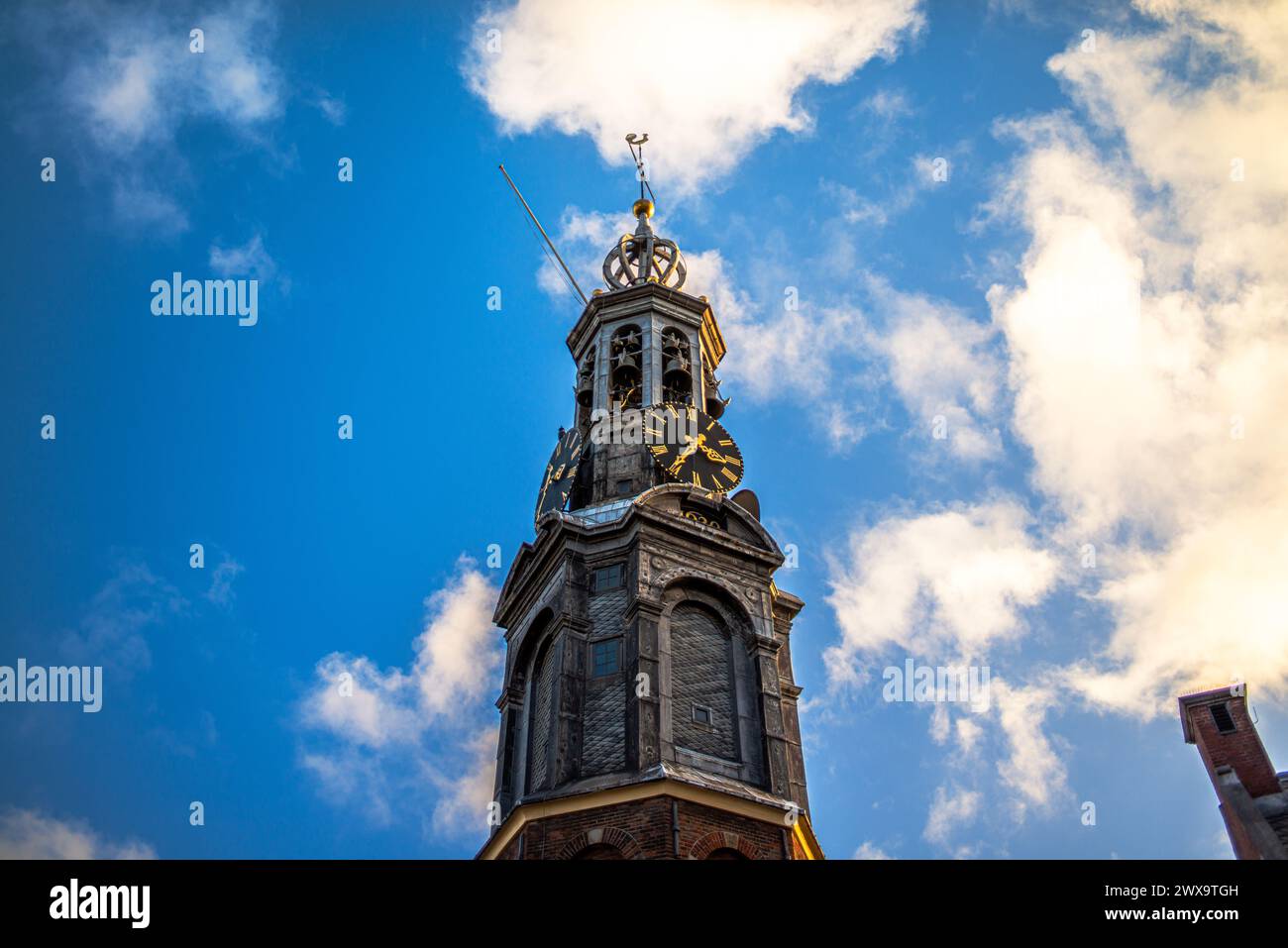 Sali in cima a una vecchia chiesa di Amsterdam per ammirare viste panoramiche, dove le guglie storiche toccano il cielo in questo iconico paesaggio urbano europeo. Foto Stock
