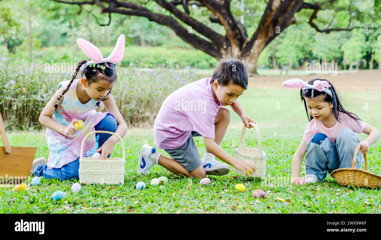 Bambini con cesti pasquali e borse in erba Foto Stock