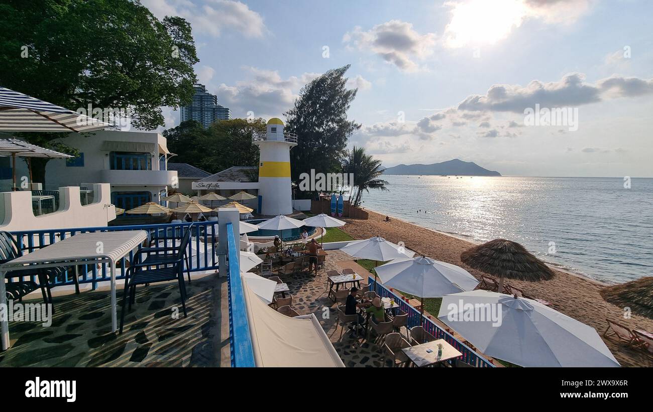 Bangsaray Pattaya Thailandia 28 febbraio 2024, giornata rilassante in spiaggia con ombrelloni e sedie colorate che punteggiano la costa sabbiosa, invitando i visitatori a rilassarsi e godersi la vista dell'oceano. Foto Stock