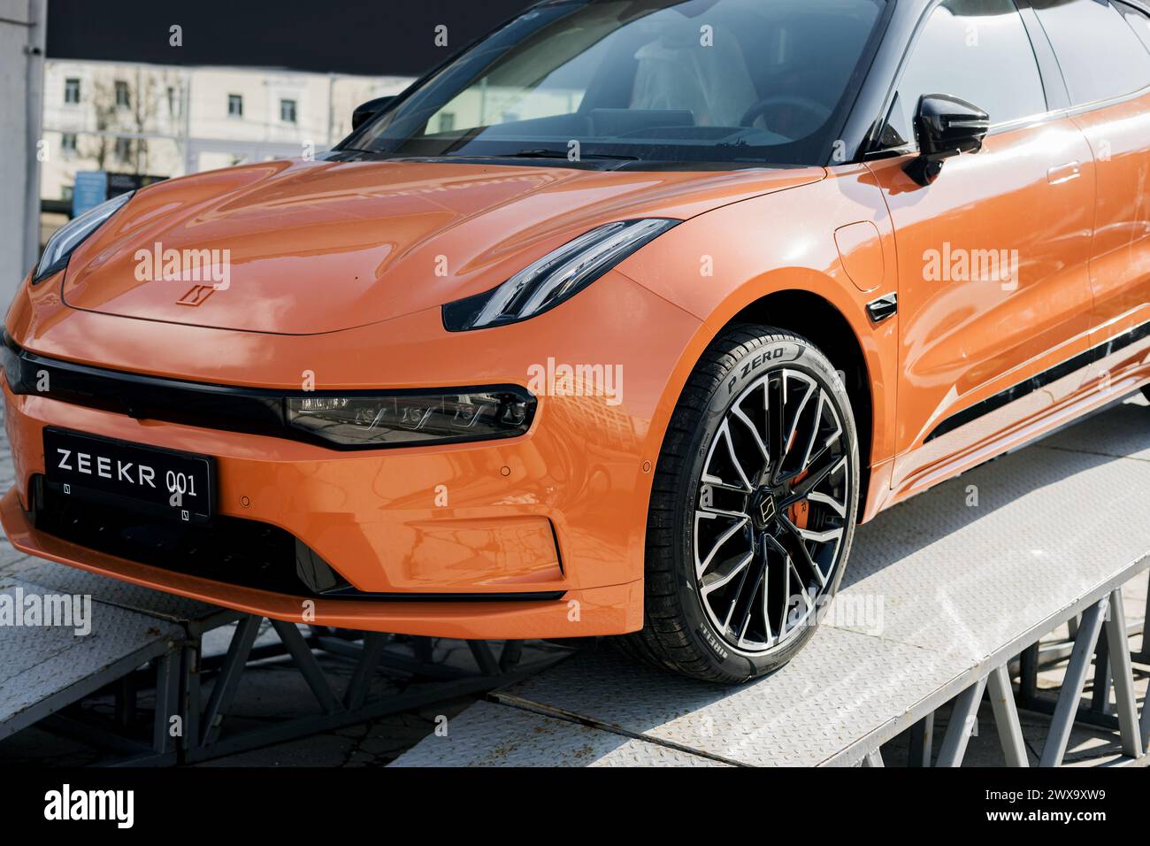 Minsk, Bielorussia, 29 marzo 2024 - auto sportiva arancione Zeekr 001 sulla piattaforma di promozione Foto Stock