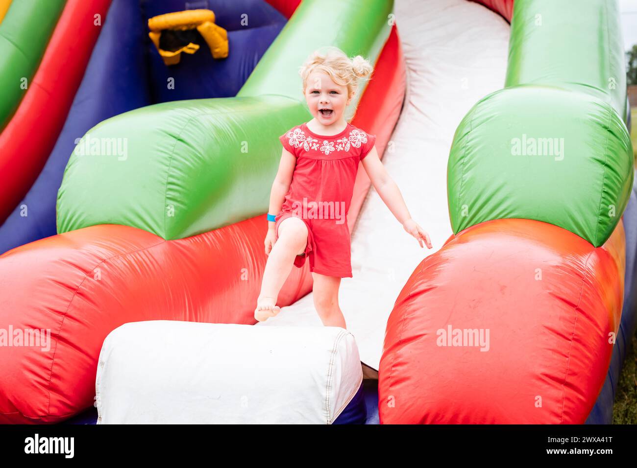 Bambino felice su gonfiabile rimbalzo casa al festival Foto Stock