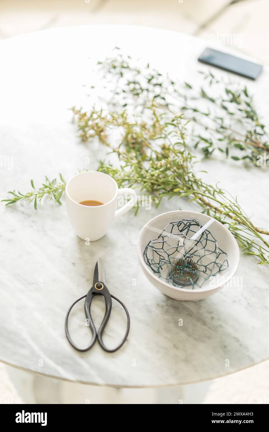 Laboratorio di fioristi con caffè su un tavolo di marmo Foto Stock