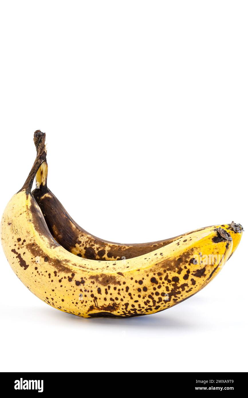 Banana matura con macchie marroni su sfondo bianco. Foto Stock