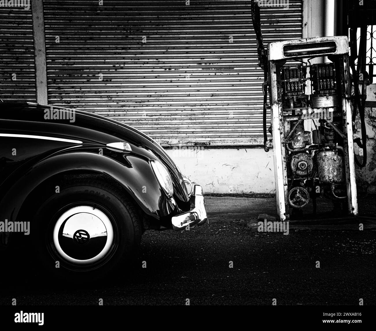 Classico VW Volkswagen Beetle Black White di fronte alla vecchia stazione di servizio pompa carburante del garage bowser. Il "Black Bug" prodotto nello stabilimento di Clayton nel 1961 Foto Stock