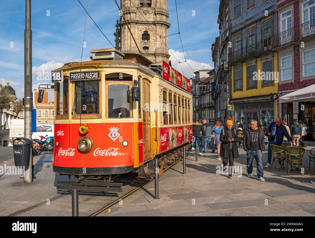 L'iconico tram rosso numero 18 fa una pausa di fronte alla Torre della Chiesa di Clérigos, Porto, Portogallo Foto Stock