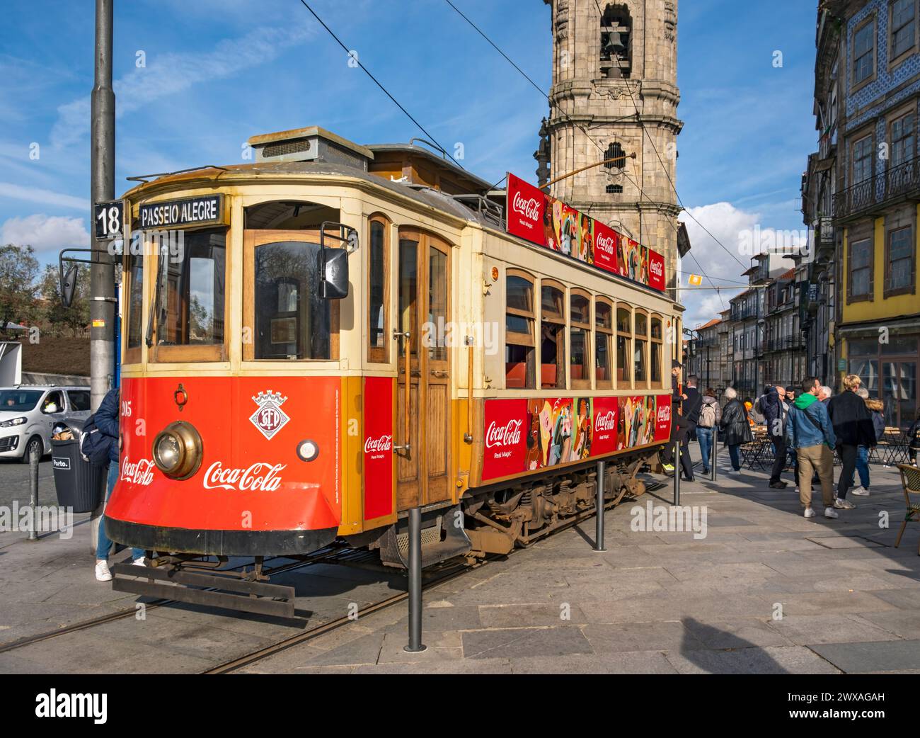 L'iconico tram rosso numero 18 fa una pausa di fronte alla Torre della Chiesa di Clérigos, Porto, Portogallo Foto Stock