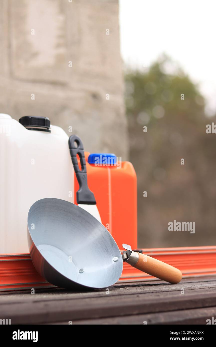 Mestolo per intonaco o da costruzione, una spatola, una livella da costruzione e un contenitore per primer. Ristrutturazione di case di campagna, costruzione. Composizione e. Foto Stock