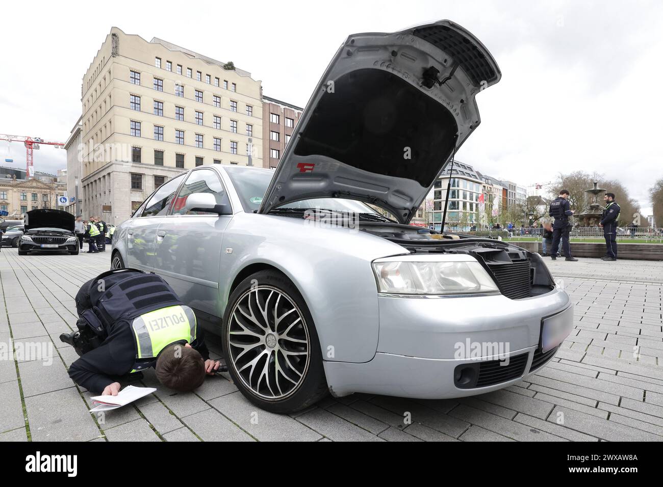 29 marzo 2024, Renania settentrionale-Vestfalia, Duesseldorf: Gli agenti di polizia ispezionano un'auto durante un controllo del veicolo. Venerdì Santo, la polizia vuole monitorare con attenzione le riunioni tradizionali della scena dell'accelerazione, del sintonizzatore e del poser nella Renania settentrionale-Vestfalia. Per anni, la polizia stradale ha aumentato il servizio il venerdì Santo, controllando i veicoli incastrati e misurando la velocità su percorsi popolari sulla scena. Agenti appositamente addestrati vengono impiegati per identificare rapidamente le modifiche non autorizzate apportate ai veicoli. Foto: David Young/dpa - ATTENZIONE: La persona o le persone sono state pixelate per la risoluzione legale Foto Stock