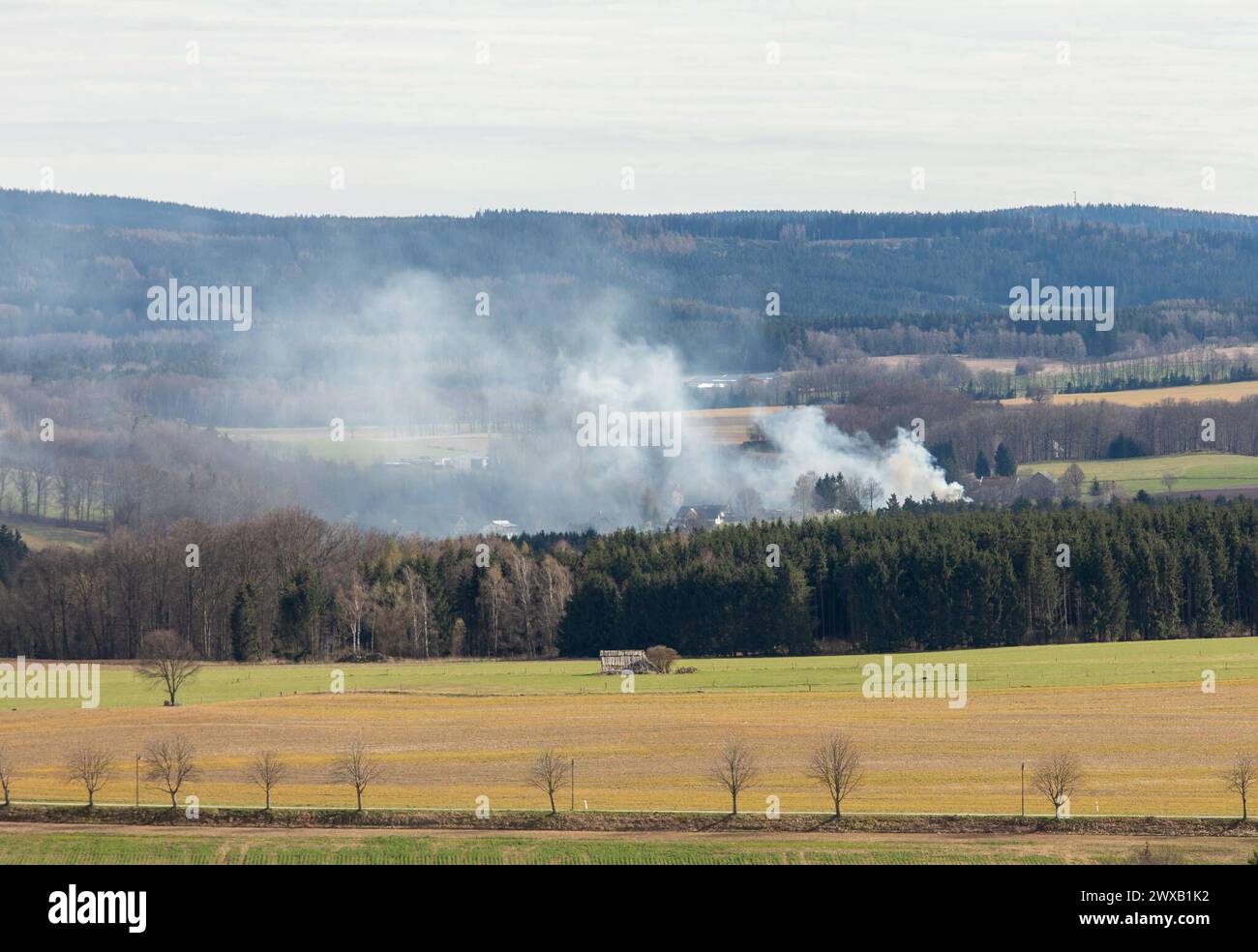 240329ID notizie del marchio: EN 2024-03-29 Unterstand komplett niedergebrannt Feuerwehr kann Übergreifen auf Wohnhäuser verhindern Kirchberg OT Stangengrün. Auf der Hirschfelder ist am Karfreitag gegen 14:30 Uhr ein Brand in einem Unterstand ausgebrochen. Zahlreiche Einsatzkräfte der Feuerwehr sind seitdem damit beschäftigt, den Brand zu löschen. Mehrere Trupps unter schwerem Atemschutz kommen hierbei zum Einsatz. VOR Ort musste eine stabile Wasserversorgung aus einem Teich in der Nähe aufgebaut werden. Dazu mussten mehrere, zirka 80 Meter lange Schlauchleitungen zum Brandort verlegt werden. MIT zwei Foto Stock