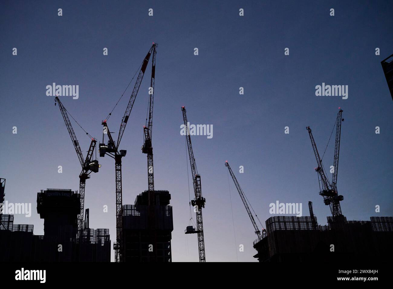 Una silhouette di gru da costruzione al crepuscolo, presso Elephant & Castle, se Londra, Regno Unito Foto Stock