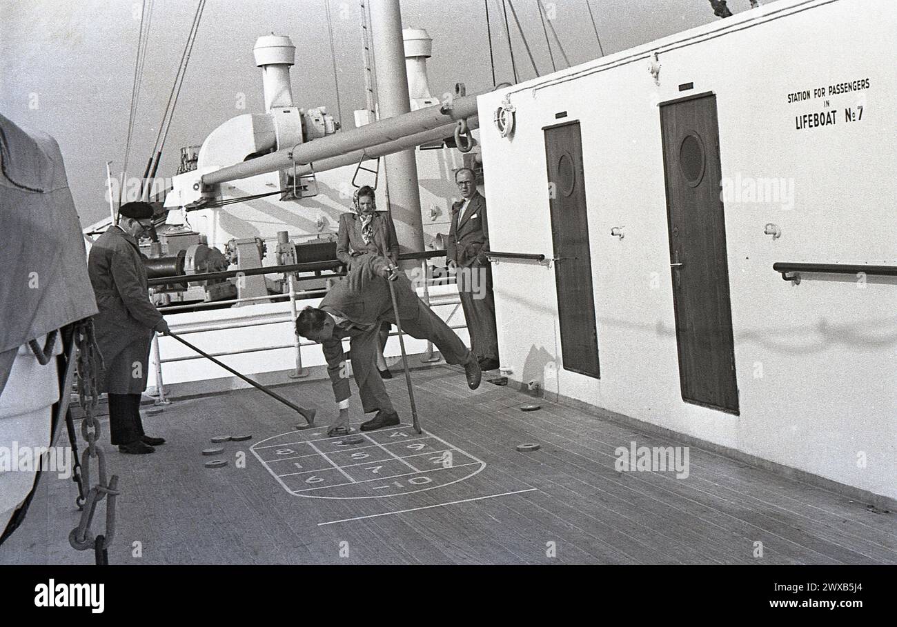 Anni '1950, storici, passeggeri maschi sul ponte che giocano a quiz, avviso sul muro, stazione per i passeggeri sulla scialuppa di salvataggio n. 7 Foto Stock