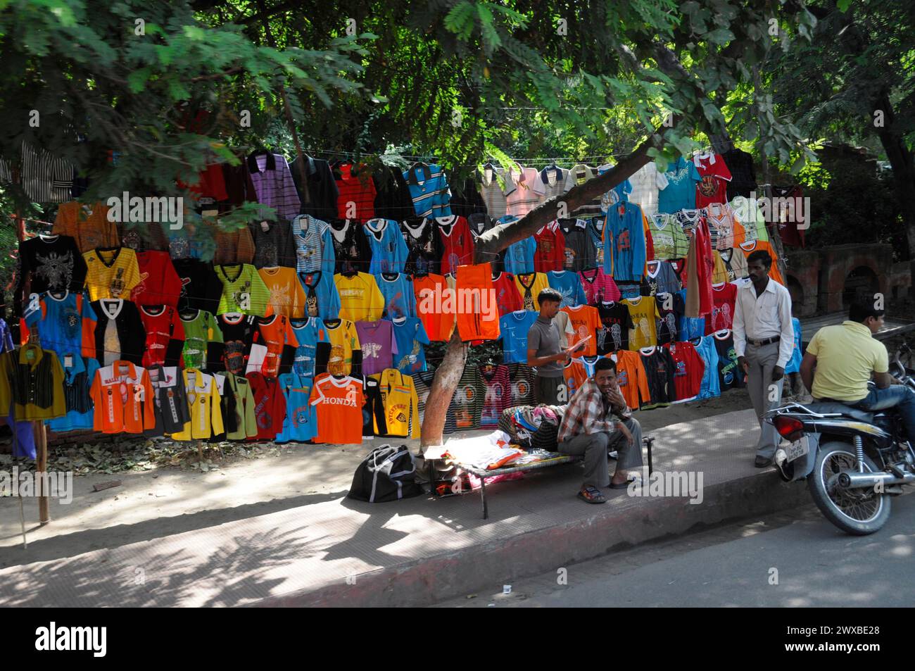 Vestiti colorati venduti sotto gli alberi in un mercato di strada, Jaipur, Rajasthan, India del Nord, India Foto Stock