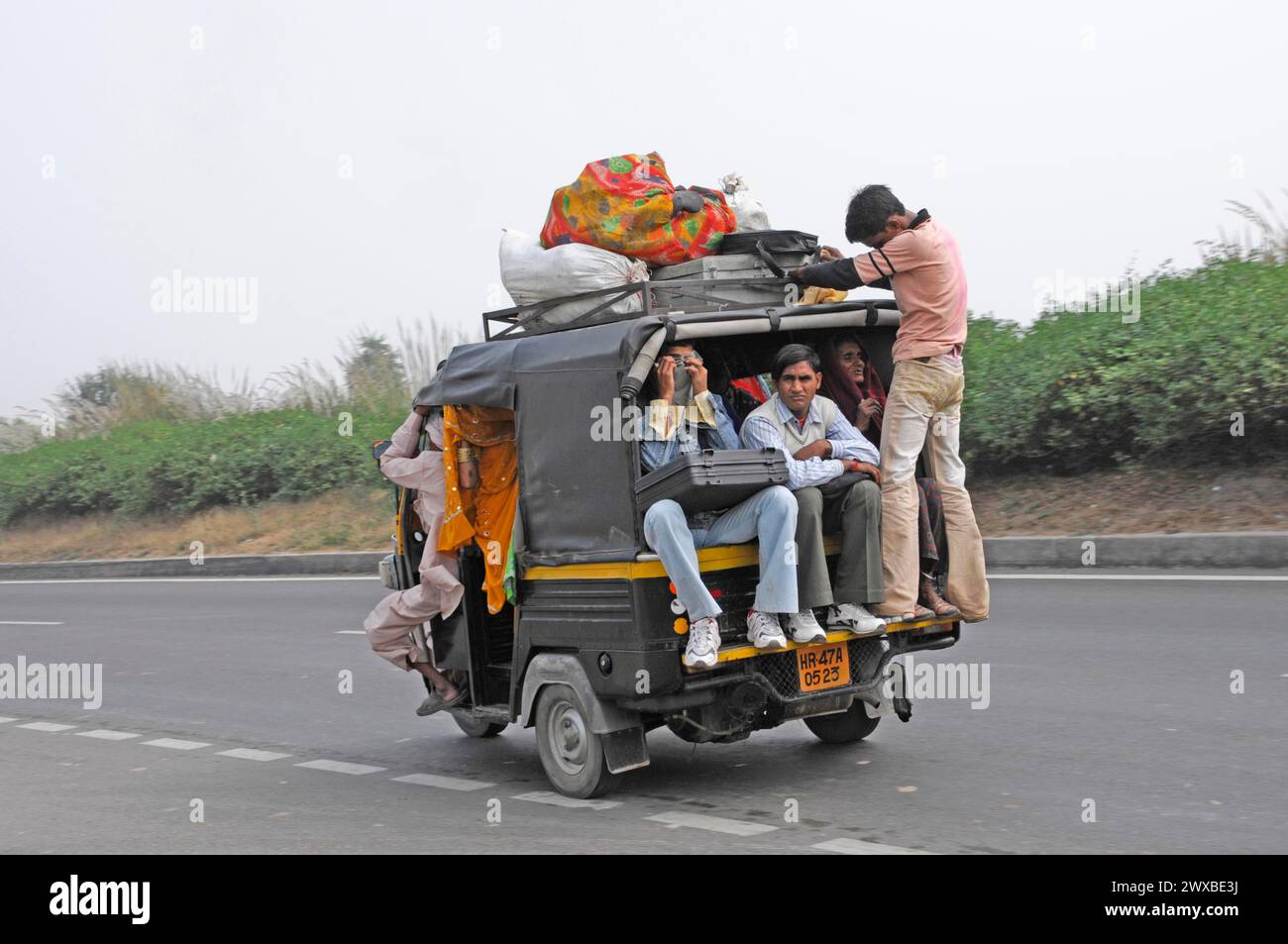 Trasporto di passeggeri in un veicolo sovraccarico su una strada, apparentemente una pratica comune, Jaipur, Rajasthan, India Foto Stock