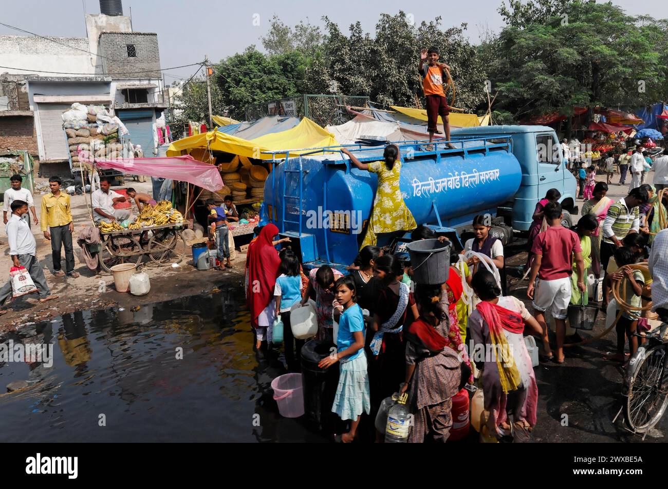 Persone, soprattutto bambini, che prendono acqua da una petroliera, Jaipur, Rajasthan, India Foto Stock