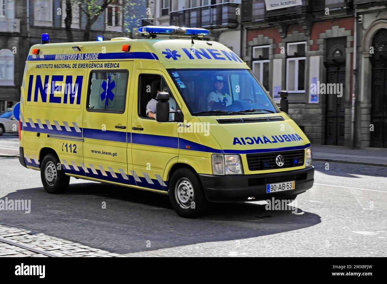 Ambulanza gialla e blu in una strada trafficata, Porto, Portogallo settentrionale, Portogallo Foto Stock