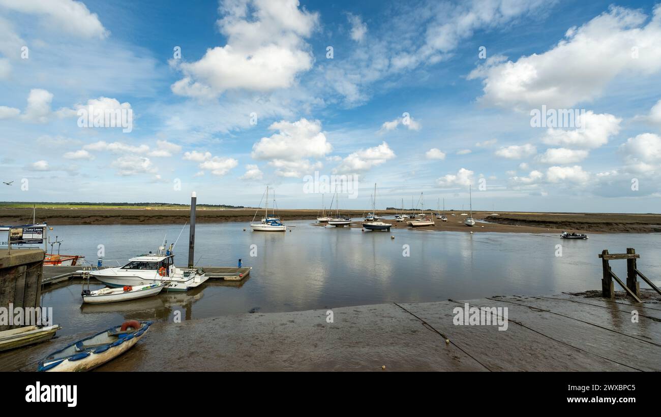 Wells, Norfolk, Regno Unito – marzo 25 2024. Barche ormeggiate nell'estuario della cittadina balneare di Wells sulla costa nord del Norfolk Foto Stock