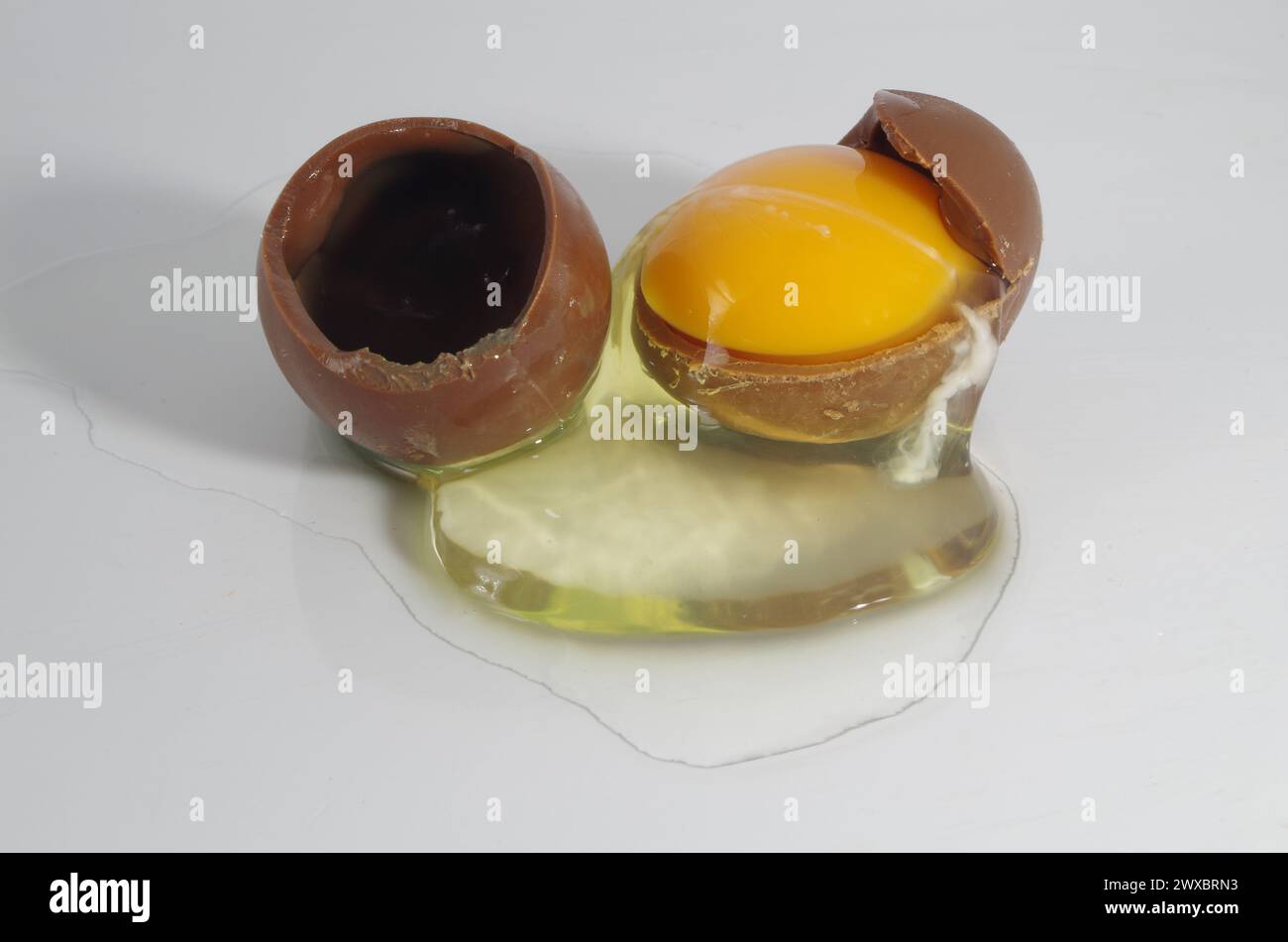 Uovo di cioccolato rotto con tuorlo d'uovo vero e bianco d'uovo. Foto Stock