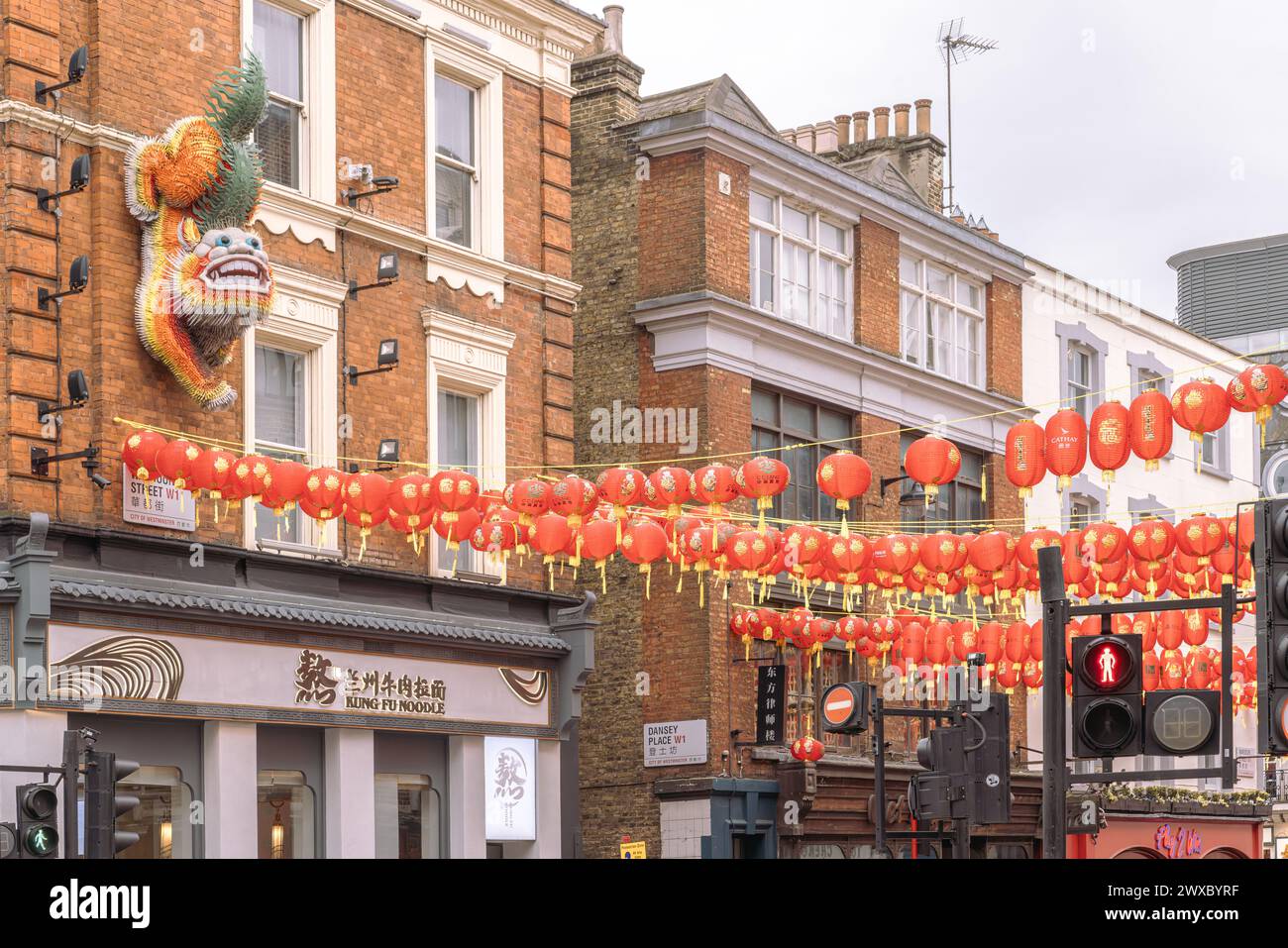 Una scultura di leone cinese montata su un edificio custodisce e accoglie i visitatori di Wardour Street a Chinatown, Londra. Lanterne cinesi e leone. Foto Stock