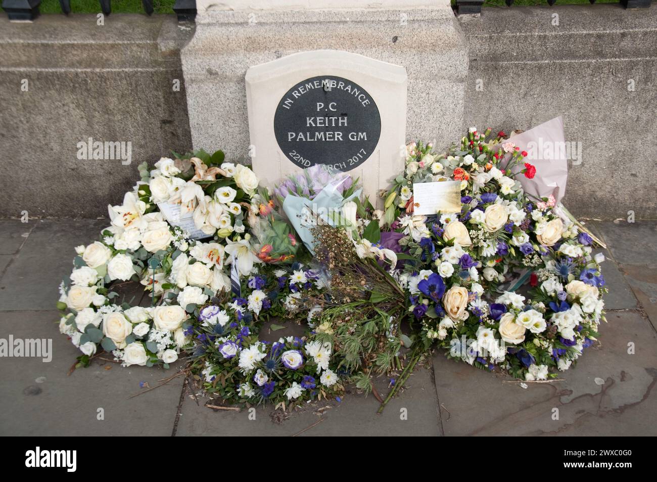 Fiori posati in memoria di PC Keith Palmer fuori dagli edifici del Parlamento, Parliament Square, City of Westminster, Londra, Regno Unito Foto Stock