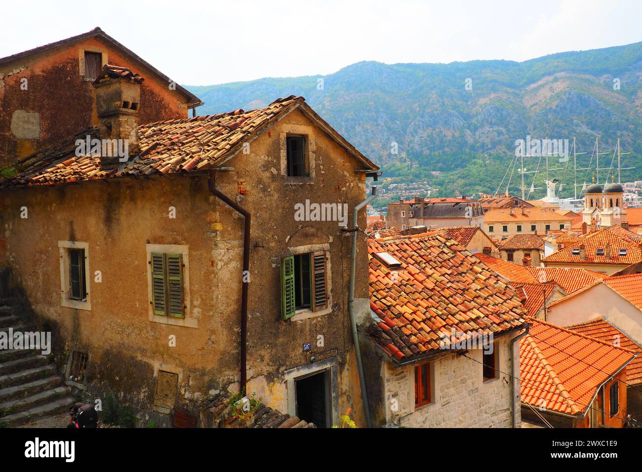 Kotor è una città costiera del Montenegro. Baia di Cattaro. Tetti di tegole rosse, montagne e camini di una nave turistica. Escursioni e turismo. Cattedrale di sa Foto Stock
