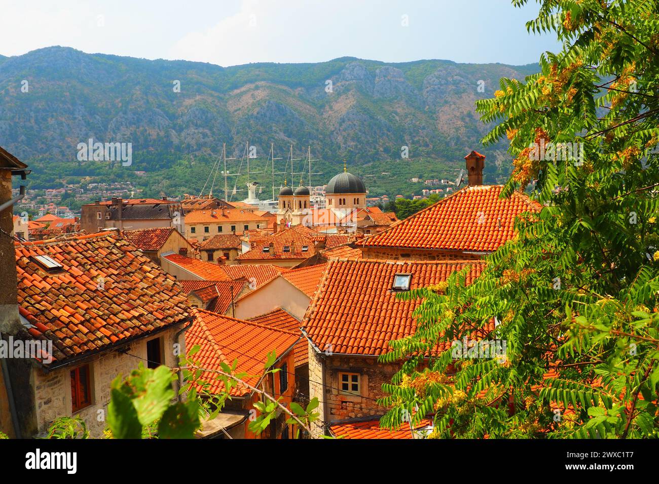 Kotor è una città costiera del Montenegro. Baia di Cattaro. Tetti di tegole rosse, montagne e camini di una nave turistica. Escursioni e turismo. Cattedrale di sa Foto Stock