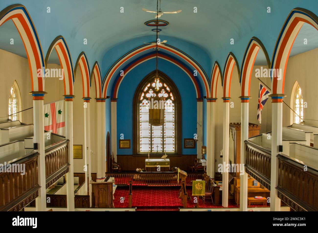 Kingston, New Brunswick, Canada. Trinity Church Interior, anglicano. Bandiera lealista a destra, bandiera anglicana a sinistra. I colori lealisti decorano il woo Foto Stock