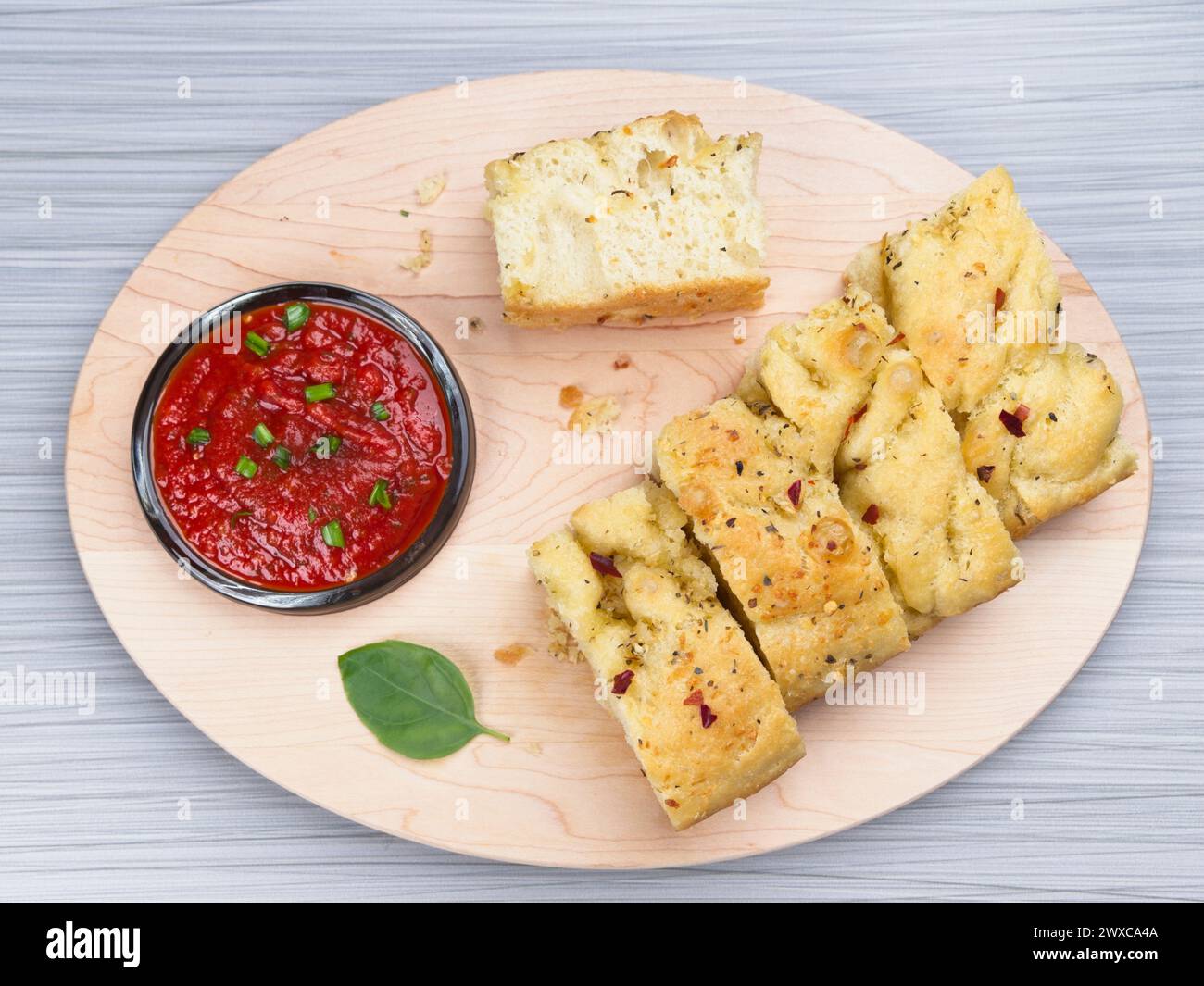 Una foto piatta di fette di focaccia e un piatto di salsa di pomodoro da immergere. Foto Stock