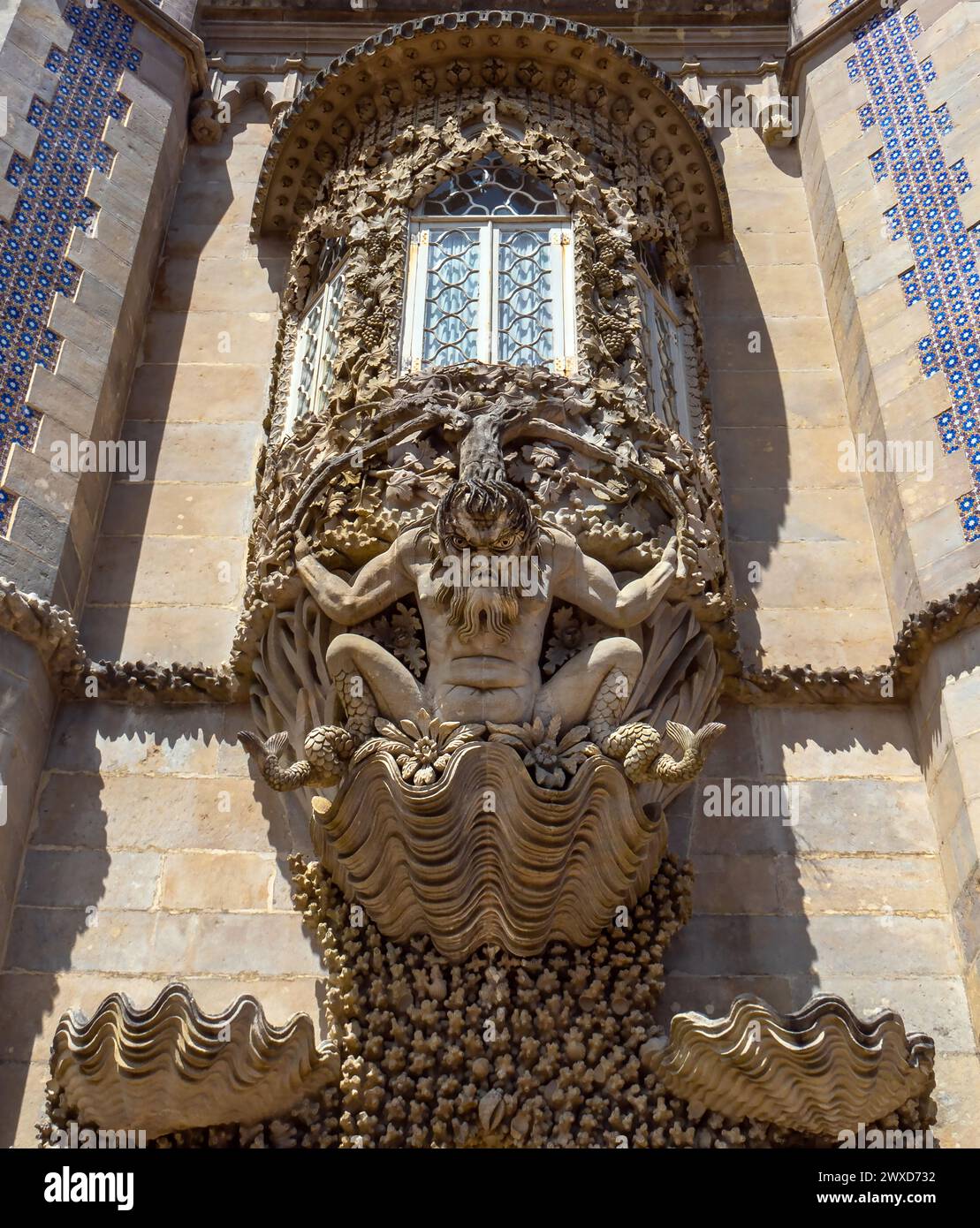 Vista dettagliata della grottesca Statua di Tritone scolpita in pietra con una coda di pesce al posto delle gambe su un guscio con motivi floreali sulla facciata del PE Foto Stock