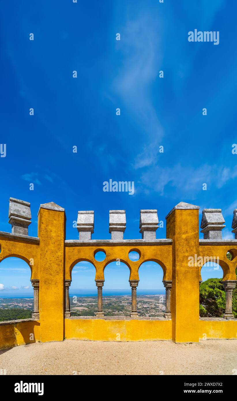 Archi moreschi del cortile ad arco con le pareti dipinte di giallo del Palácio da pena, con la catena montuosa di Sintra e l'Oceano Atlantico sul Foto Stock