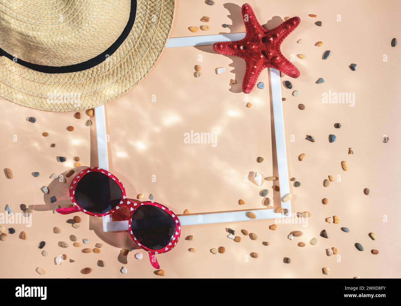 appartamento estivo. Cappello, stelle marine, occhiali da sole, conchiglia e cornice quadrata bianca sullo sfondo di Champagne Sail. concetto di mare, vacanza. vista dall'alto Foto Stock