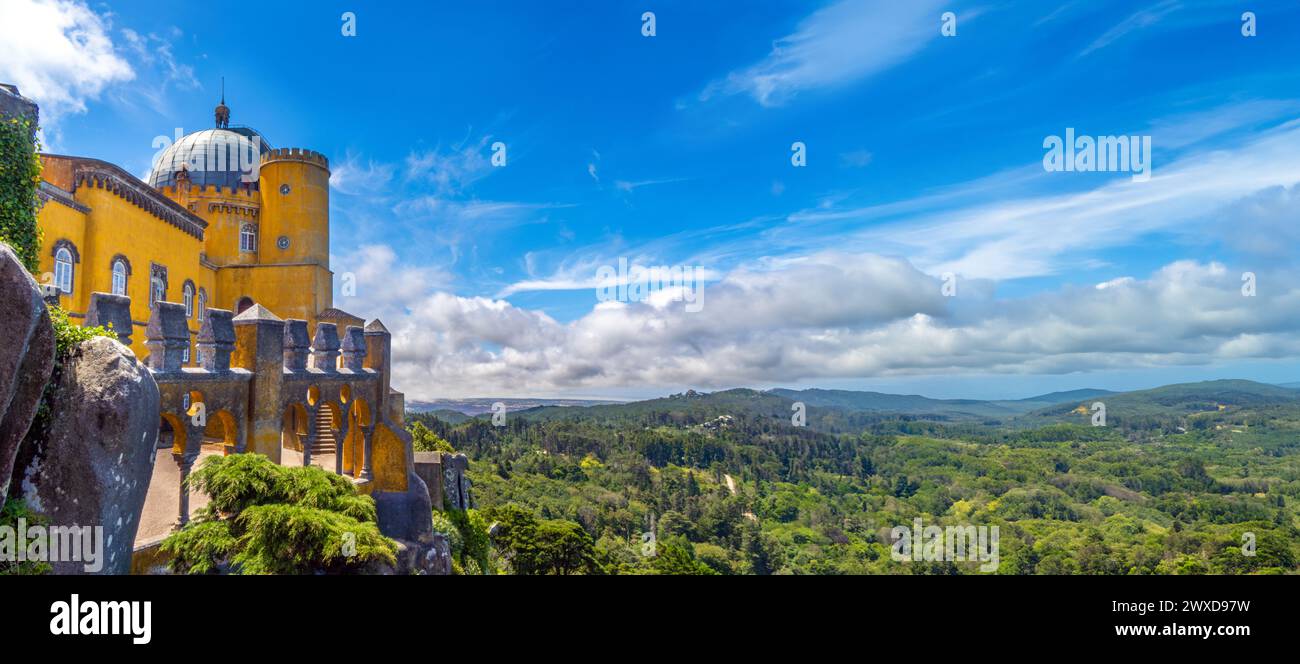 Vista panoramica esterna degli archi moreschi del Palácio da pena con la catena montuosa di Sintra sotto un cielo azzurro soleggiato con nuvole basse. Portogallo Foto Stock