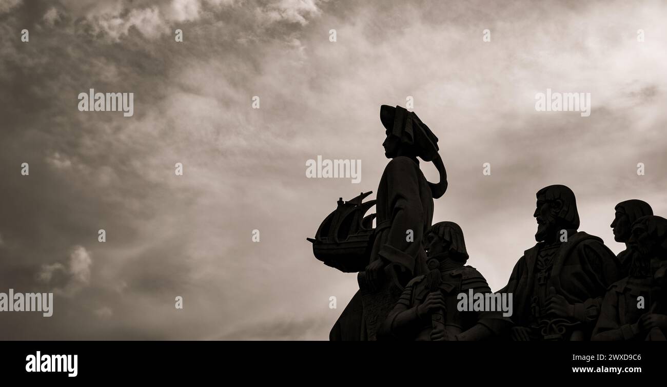 Sagome retroilluminate di sculture in pietra calcarea e Enrico il Navigatore che tiene in mano una nave dal Monumento alle scoperte a Lisbona con una S. Foto Stock