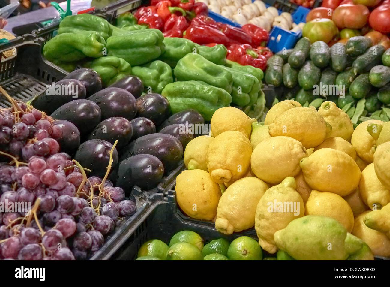 Primo piano di uve, limoni, melanzane, funghi, pepe, cetriolo, pomodoro in una bancarella di verdure del mercato Graca a Ponta Delgada, Azzorre, Portogallo Foto Stock