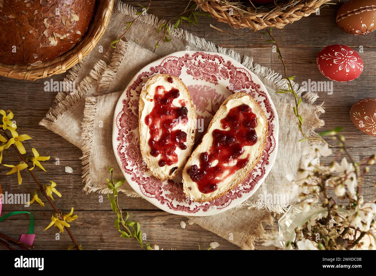 Due fette di dolce dolce dolce pasquale ceco chiamato mazanec con burro e marmellata rossa su un piatto, vista dall'alto Foto Stock