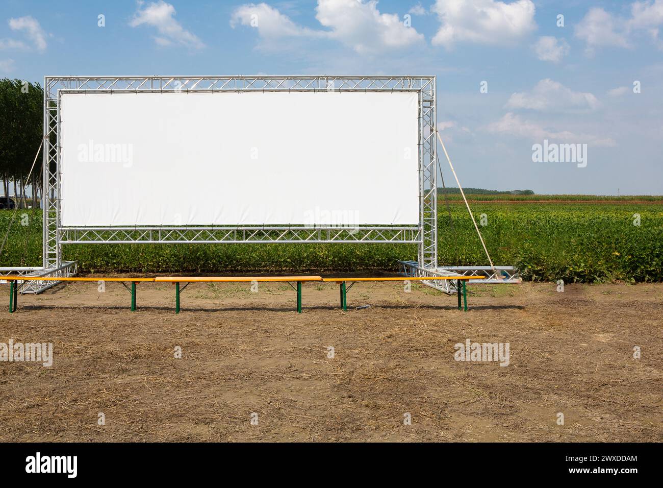 Uno schermo cinematografico ampio e vuoto si trova in primo piano in un ambiente rurale, offrendo uno spazio pubblicitario ideale per gli esperti di marketing Foto Stock
