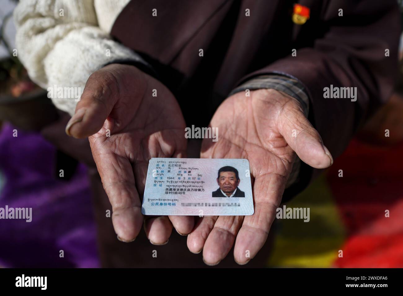 (240330) -- LHASA, 30 marzo 2024 (Xinhua) -- questa foto scattata l'11 marzo 2024 mostra la carta d'identità di Drakpa Wangden. Nato nel 1944, Drakpa Wangden vive ora nel distretto di Doilungdeqen di Lhasa, nella regione autonoma di Xizang nel sud-ovest della Cina. Prima della riforma democratica, Drakpa Wangden e la sua famiglia erano servi, lavorando su manieri affiliati a due monasteri nell'attuale Lhasa. Per la sua famiglia, ogni primavera significava prendere in prestito semi dai loro padroni, tuttavia, non potevano raccogliere nulla durante il raccolto autunnale. A quel tempo, il sostentamento della famiglia di Drakpa Wangden, composta da nove persone, era una scarsa ciotola Foto Stock