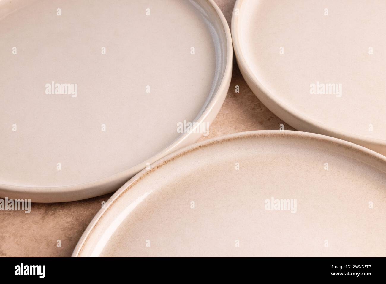 Piatti in ceramica beige su un piano in pietra marrone. Foto Stock