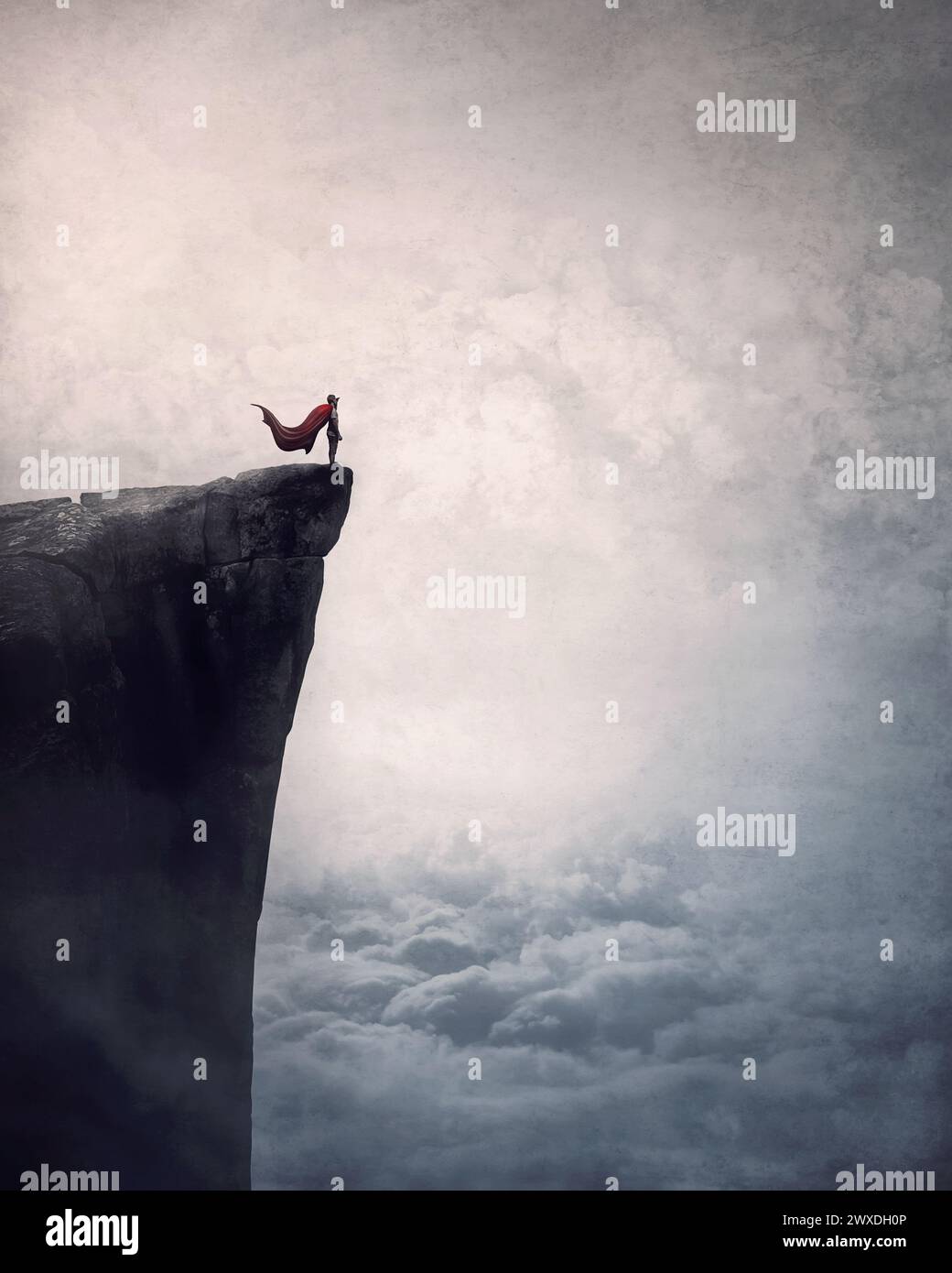 Supereroe con mantello si trova coraggioso sul bordo di una scogliera sopra le nuvole alla ricerca determinata all'orizzonte con mano in fronte. Potente concetto eroe Foto Stock