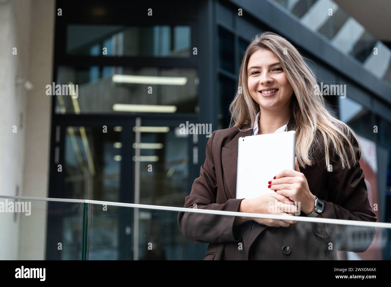 Ritratto di una donna d'affari di successo che utilizza un tablet digitale di fronte a un moderno edificio di uffici aziendali. Donna professionista, esperta di finanza, proje Foto Stock