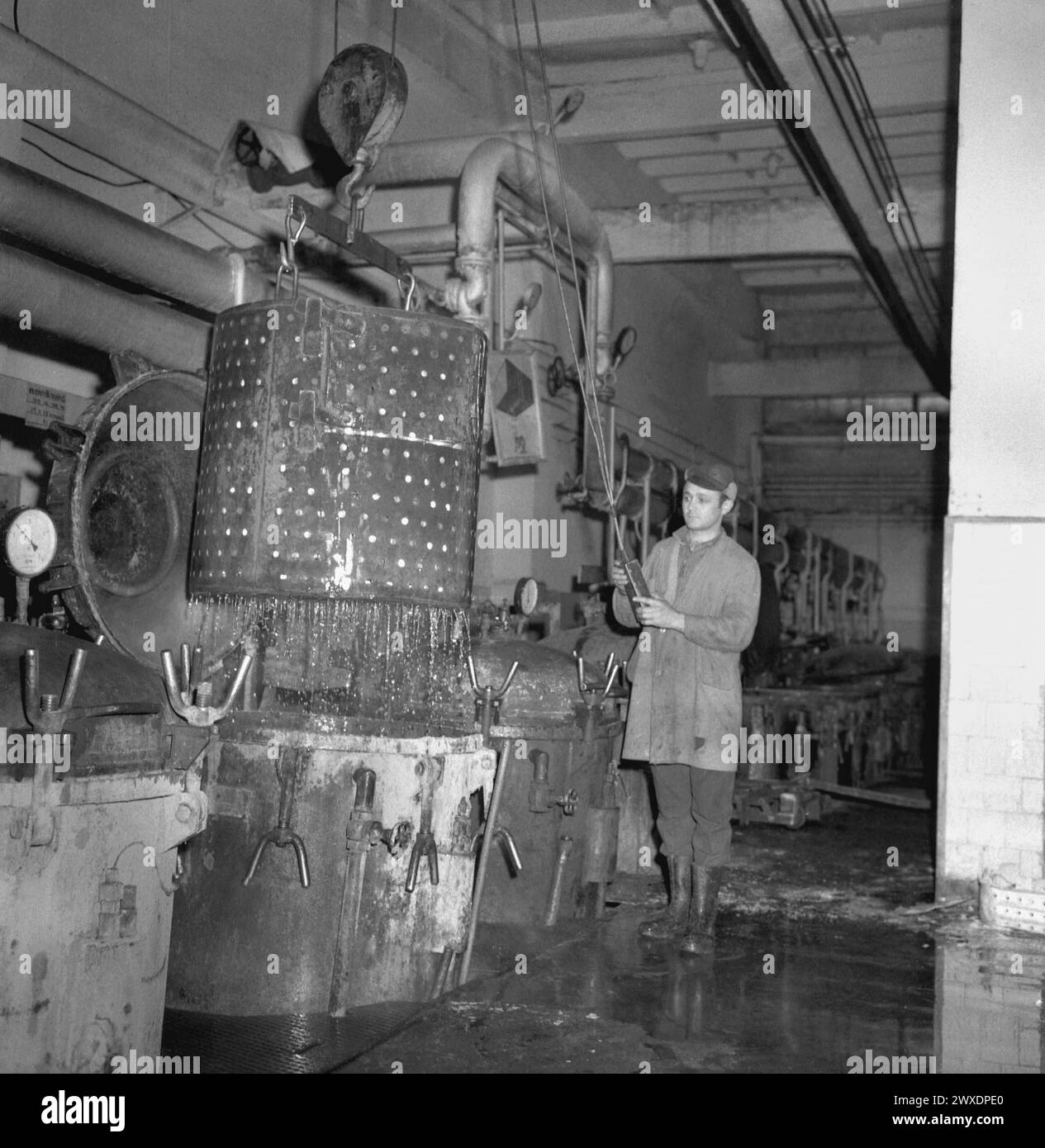 Repubblica Socialista di Romania negli anni '1970 Operaio che gestisce bombole industriali a pressione in una fabbrica di conserve alimentari di proprietà statale. Foto Stock