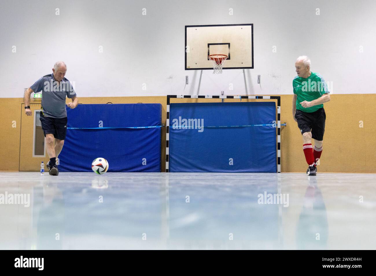 Fußball in Deutschland Göttingen, Deutschland - 26. März 2024: Zwei Senioren tragen Fußballschuhe der Marke adidas und spielen Fußball mit einem offiziellen Spielball für die Euro 2024 in Deutschland mit dem Aufdruck adidas EURO24 Fußballliebe Pro. Niedersachsen Foto Stock