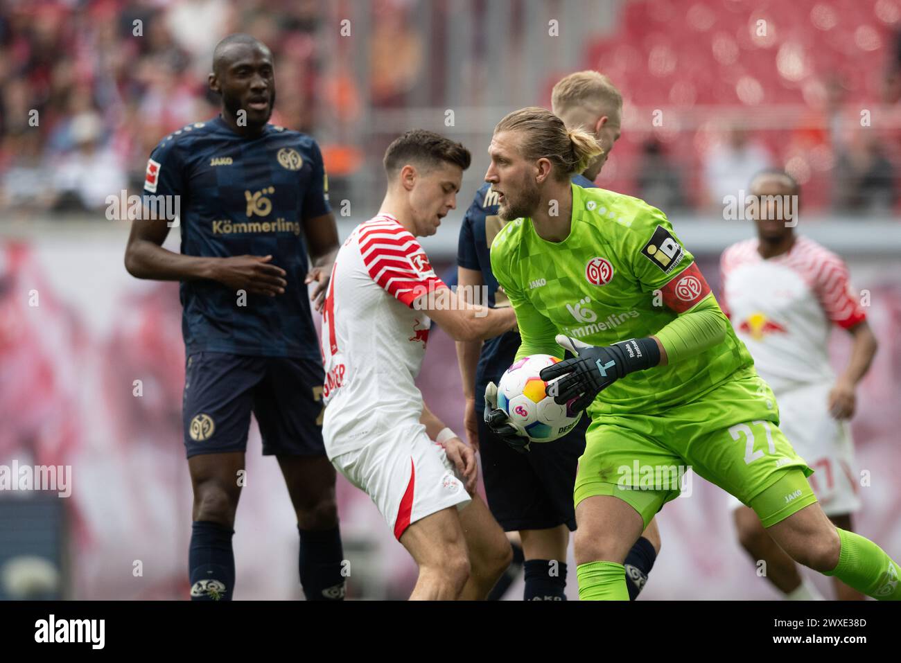 Lipsia, Germania. 30 marzo 2024. Calcio, Bundesliga, RB Leipzig - FSV Mainz 05, Matchday 27, Red Bull Arena. Il portiere del Mainz Robin Zentner disinnesca una palla davanti al suo gol. Credito: Hendrik Schmidt/dpa - NOTA IMPORTANTE: in conformità con i regolamenti della DFL German Football League e della DFB German Football Association, è vietato utilizzare o far utilizzare fotografie scattate nello stadio e/o della partita sotto forma di immagini sequenziali e/o serie di foto video./dpa/Alamy Live News Foto Stock