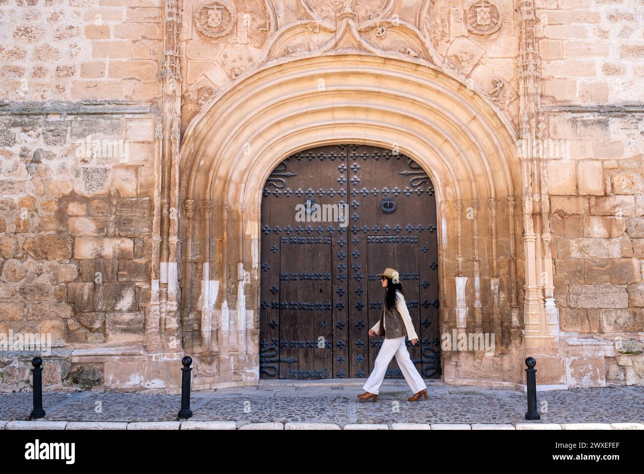 Viaggiatrice di mezza età che cammina sul cancello storico della chiesa di nostra Signora dell'assunzione, che è una chiesa cattolica del XVI secolo a Tembleque Foto Stock